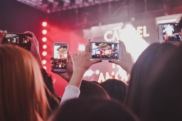 a crowd of content ambassadors holding smartphones to record a concert